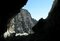 Dall'interno del tunnel si intravedono le montagne circostanti e un escursionista appena fuori dal Buco di Viso