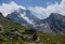 Escursionisti sul sentiero tra praterie alpine, sullo sfondo il Monviso con il dado di vallanta